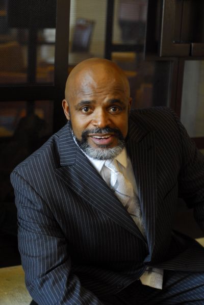 Bald man in pinstripe suit smiling.