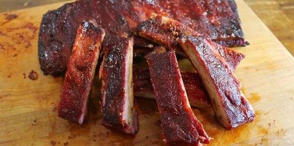 Smoky barbecue ribs on a wooden board.