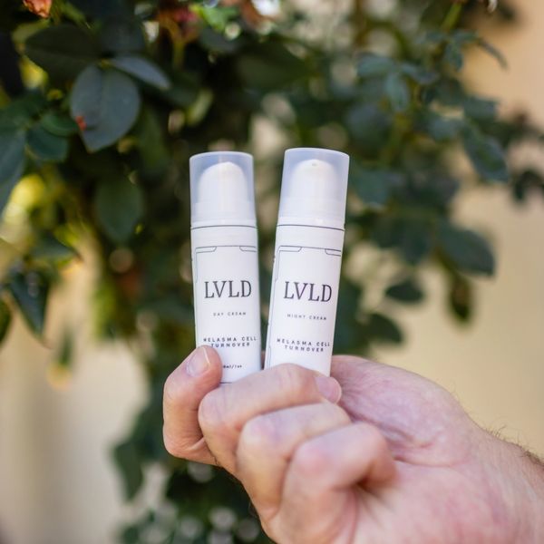 Hand holding LVLD day and night creams for melasma cell turnover.