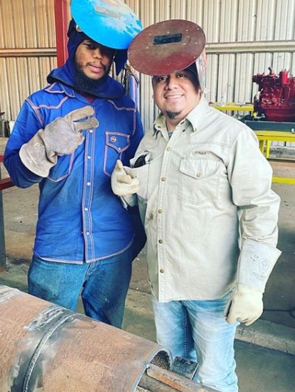 Glenson (student) and Julio (Director) celebrating a successfully completed pipe weld.