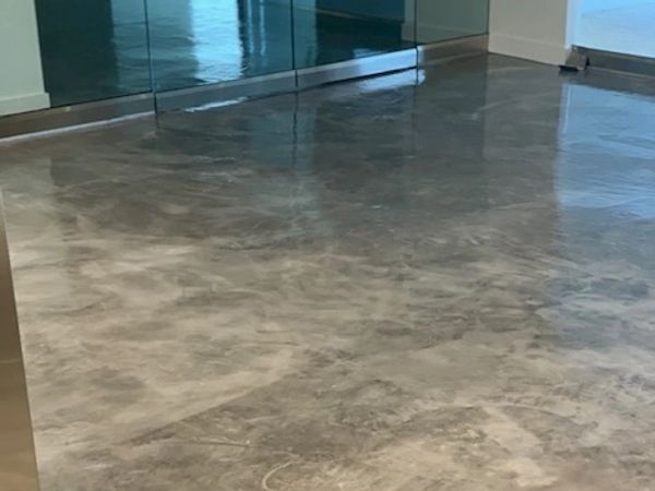 Polished concrete floor reflecting light in a modern interior space.