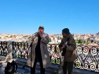 Two street musicians performing with city view.
