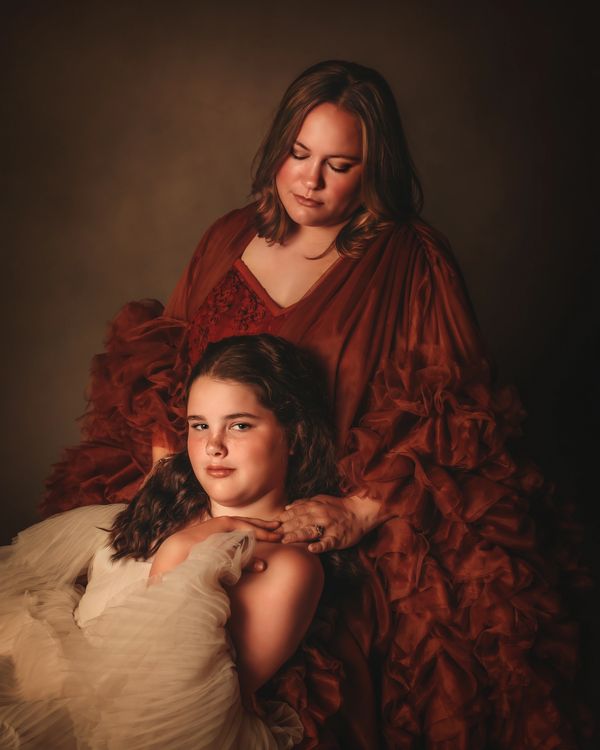 mom and daughter in fine art gowns showing affection