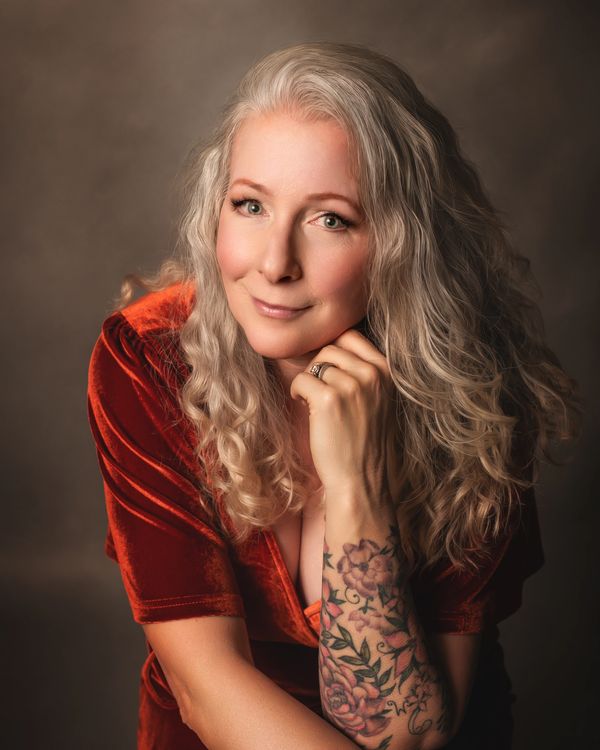 Close up portrait of a white-haired woman in an orange dress