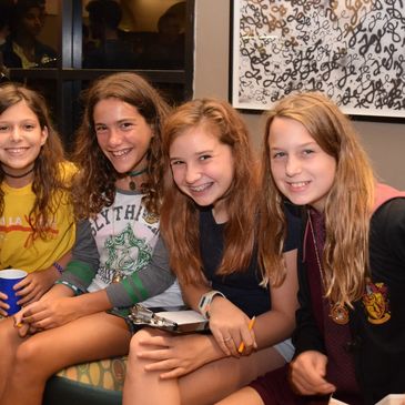 Four teenage girls smiling.