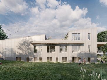 Modern beige house with large windows and green lawn under a cloudy sky.