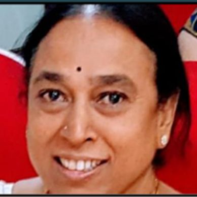 Close-up of a smiling woman wearing a small bindi.