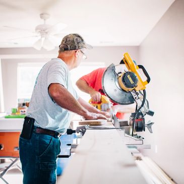 Men cutting a plank of wood