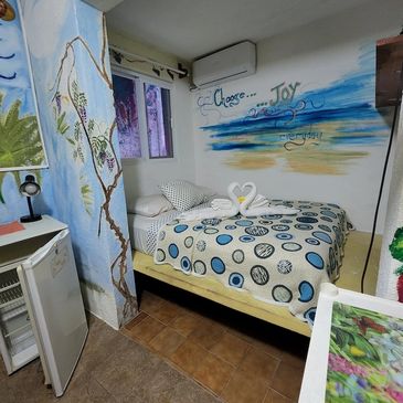 Cozy bedroom with artistic wall paintings and a bed with swan towel arrangement.