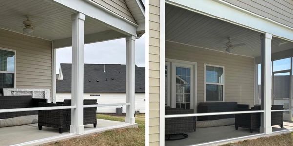 A cozy screened-in porch with black wicker furniture and ceiling fans.