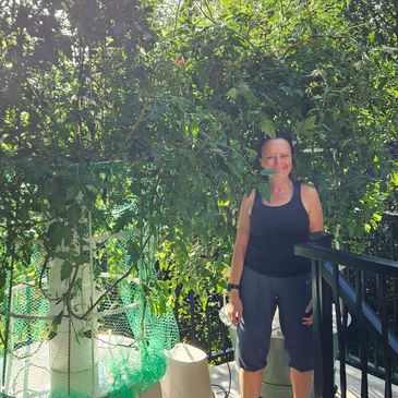 Female gardener standing next to vertical growing system