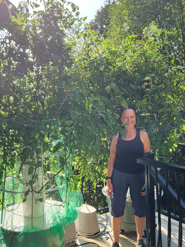 Female gardener standing next to vertical growing system