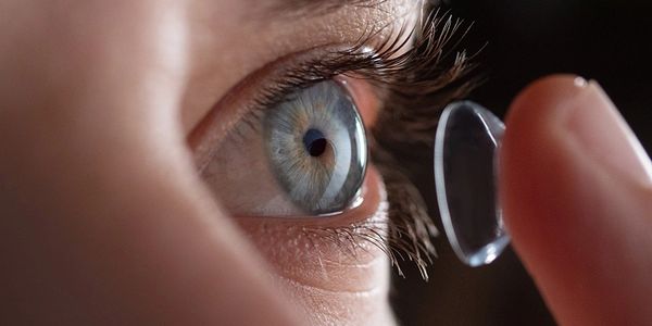 Close-up of an eye with contact lens about to be placed.