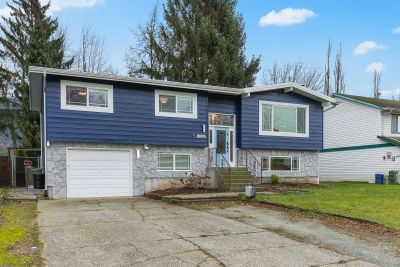 Two-story house with blue siding and stone facade.