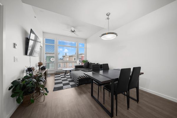 Minimalist living-dining room with black furniture and large window.