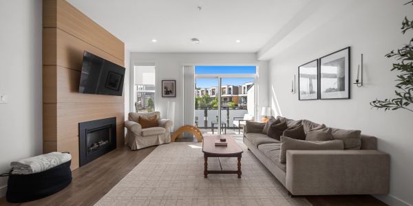 Modern living room with neutral tones and large glass doors.