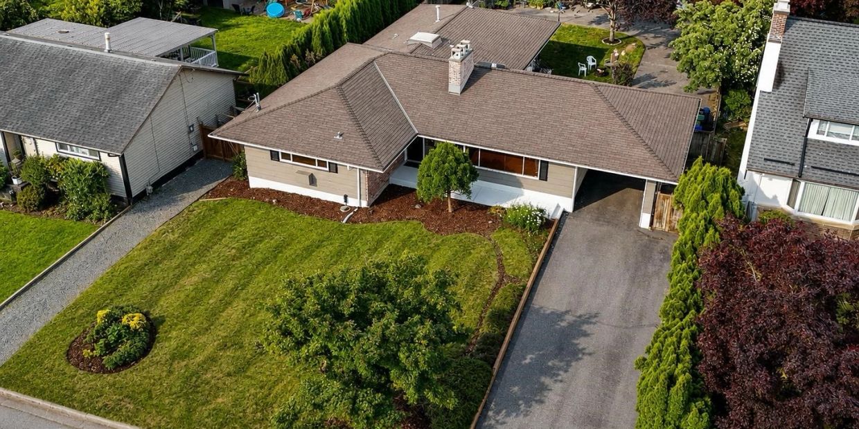 A single-story suburban house with a large front lawn and driveway.