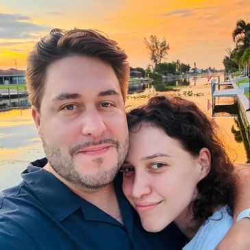 2 People smiling on a canal during a sunset