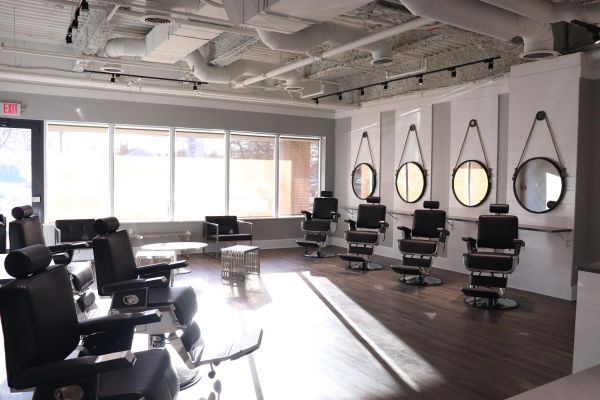 Modern and bright barbershop interior with multiple grooming chairs.