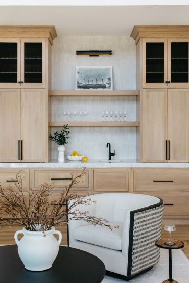Modern living space with wooden cabinets and a cozy armchair.