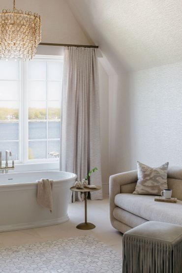 Cozy bathroom with a freestanding tub and comfortable seating area.