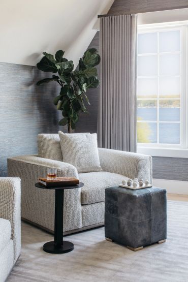 Cozy modern living room with textured armchair and large window.