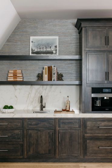 Modern kitchen with dark wood cabinets and marble countertops.
