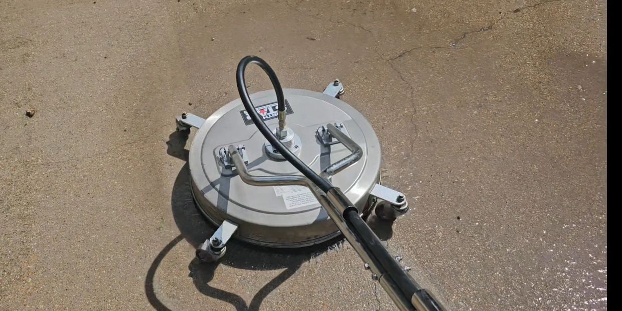 A pressure washer surface cleaner cleaning a concrete floor.