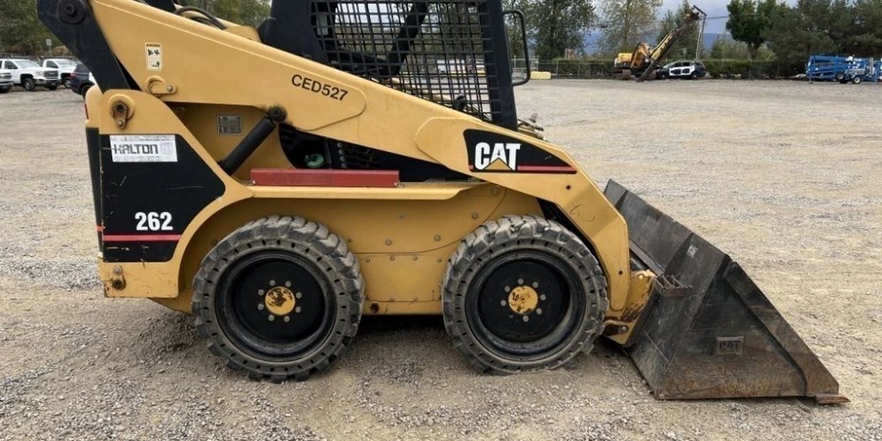 Yellow CAT skid steer loader on gravel.