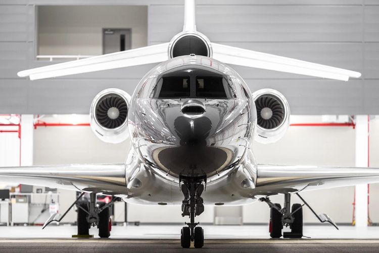 Stack of books next to pencils in a holder and a camera.