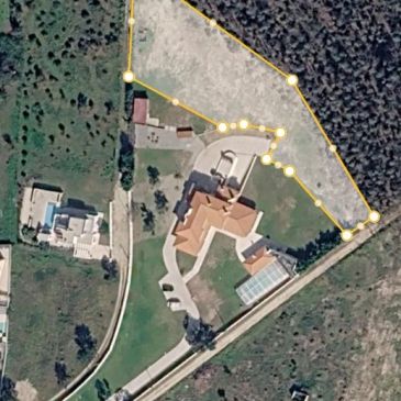 Aerial view of a property with buildings and outlined land area.