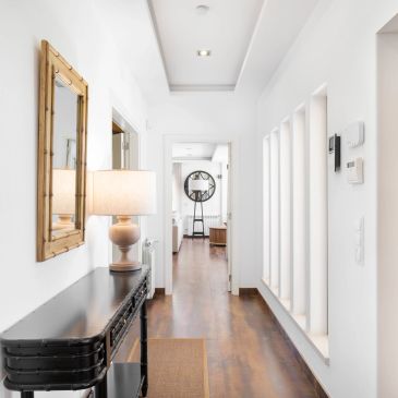 Bright hallway with wooden floor and lamp.