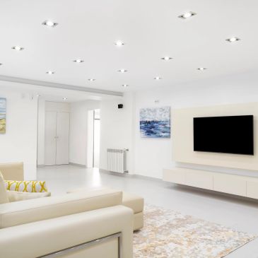 Bright modern living room with beige sofa and wall-mounted TV.