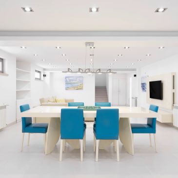 Modern dining room with blue chairs and white table.