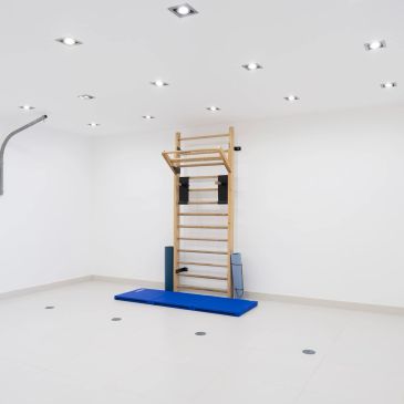 Minimalist gym corner with wall bars and mat.