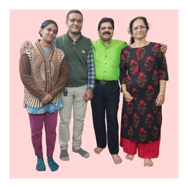 Group of four adults posing together indoors.