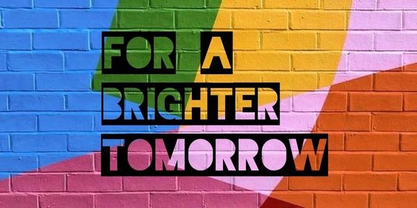 Cut out letters on a brick background painted in many bright colors says: For a brighter tomorrow