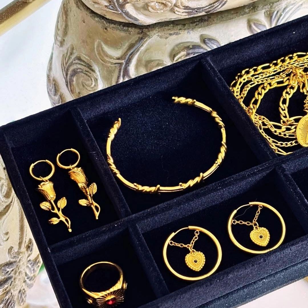 Elegant gold jewelry set displayed in a black velvet organizer.