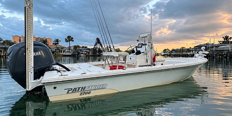 White Pathfinder 2200 boat docked at sunset with fishing rods.