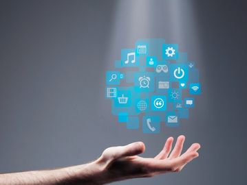 Hand projecting digital app icons in light beam.