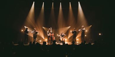 String ensemble performing on stage with dramatic lighting.