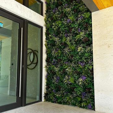 Vertical garden wall beside glass doors in a modern space.