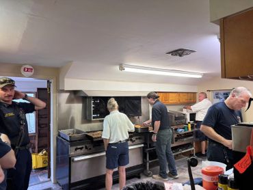 People cooking together in a commercial kitchen.