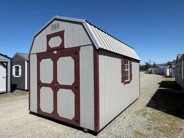 A gray and maroon wooden storage shed with double doors and a white metal roof.