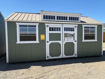 Green and white outdoor shed under blue sky.