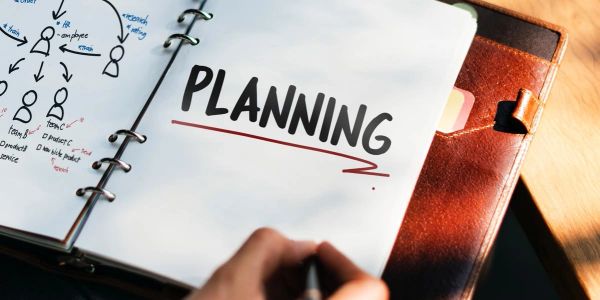 Open planner with the word 'PLANNING' and flowchart sketches.