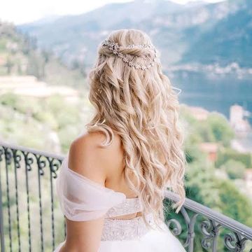Bride with long curly hair looking at a scenic view.