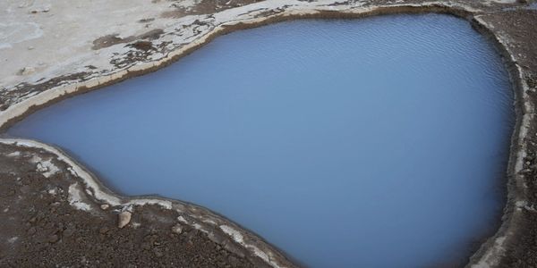 Blue water body surrounded by dry land.