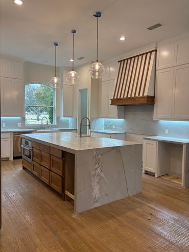 This custom kitchen features a 10' long stained white oak island topped with a unique quartzite top 