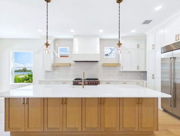 Modern kitchen with large island and pendant lights.